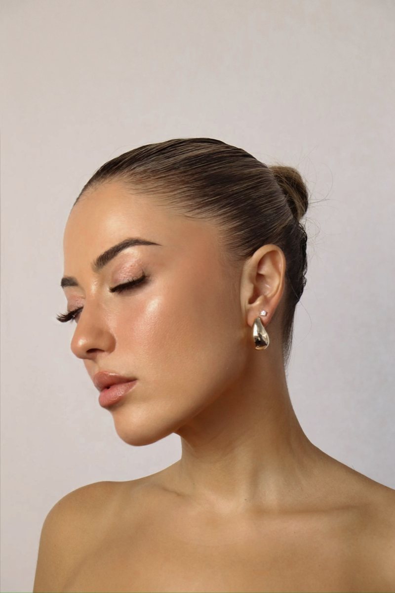 Profile with a slick bun and gold drop earring