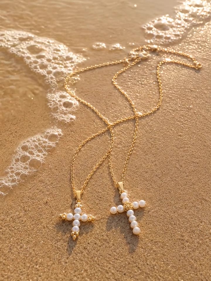 AI video: pearl cross necklaces on wet sand